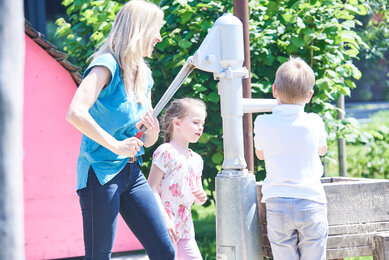 Mutter mit Kindern am Wasserspielplatz im Bio-Bengelchen Garten | © SONNENTOR /@nudlholz.at