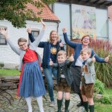 Das Foto zeigt Manuela Raidl-Zeller mit Edith Gutmann und deren 3 Kinder vorm Eingang im Garten von SONNENTOR Sprögnitz. | © SONNENTOR