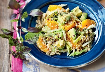 Auf dem Foto ist ein Orangen Avocado Salat auf einem blauen Teller angerichtet zu sehen. | © SONNENTOR