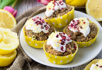 Auf dem Foto sieht man Zitronen-Mohn Muffins auf einem Teller. Auf de weißen Haube sind Gewürzblüten zu sehen. | © SONNENTOR