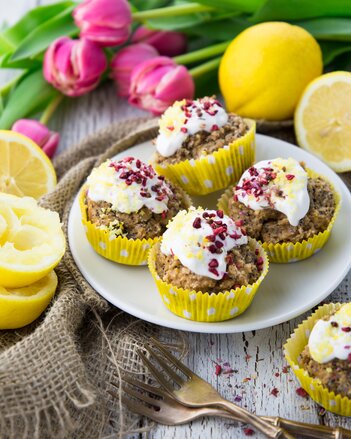 Auf dem Foto sieht man Zitronen-Mohn Muffins auf einem Teller. Auf de weißen Haube sind Gewürzblüten zu sehen. | © SONNENTOR