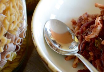 Auf dem Foto ist ein Teller mit Pasta zu sehen. Daneben sieht man zwei große Glasgefäße mit Pasta darin. | © SONNENTOR