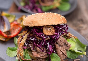 Auf dem Foto ist ein Pulled Beef Burger zu sehen. Im Burger ist auch Vogerlsalat und Kohl zu sehen. | © SONNENTOR