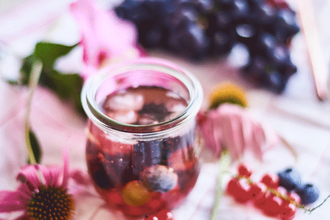 Auf dem Foto ist die Bengelchen Bowle mit Wacholderbeeren zu sehen. Daneben sind Ribiseln, Heidelbeeren und Blüten zu sehen. | © SONNENTOR