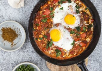 Auf dem Foto ist eine Pfanne mit Shakshuka zu sehen. Sie ist mit frischer Petersilie bestreut. | © SONNENTOR