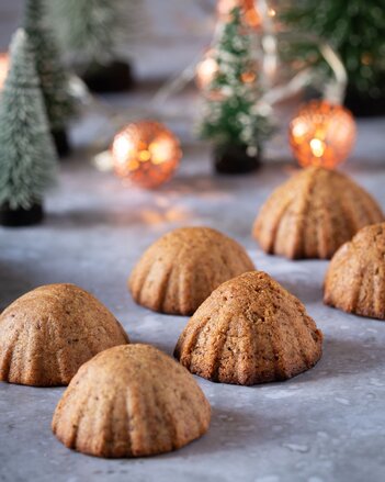 Auf dem Foto sind Mandel-Dattelplätzchen zu sehen. Im Hintergrund sieht man eine Lichterkette und Miniatur Christbäume. | © SONNENTOR