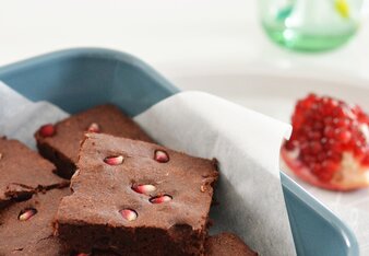 Auf dem Foto ist eine Kuchenform mit glutenfreiem Schokokuchen zu sehen. Im Kuchen sieht man Granatapfelkerne. | © SONNENTOR