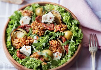 Auf dem Foto ist eine Schüssel gefüllt mit Salat und Risotto zu sehen. Im Hintergrund liegen aufgeschnittene Baguette. | © SONNENTOR