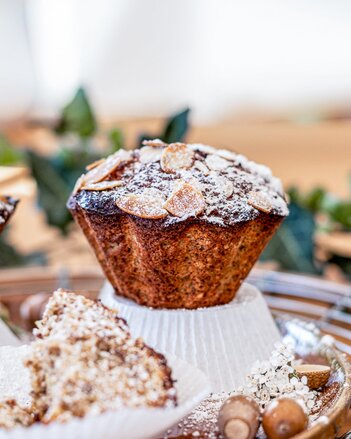 Auf dem Foto sieht man einen orientalischen Zucchini Muffin auf einer umgedrehten Muffinform stehen. Der Muffin ist mit Staubzucker bestäubt. | © SONNENTOR