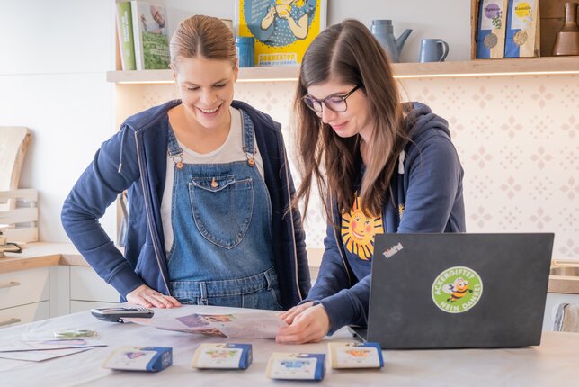 Das Bild zeigt zwei Mitarbeiterinnen, die gerade einen Folder anschauen, die Räuchermischungen liegen davor auf dem Tisch.  | © SONNENTOR