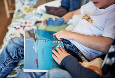 The photo shows a boy looking at a book. | © SONNENTOR