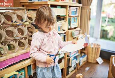 In the photo you can see a girl cutting paper. | © SONNENTOR