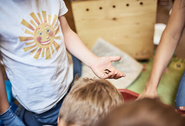 In the photo you can see a child holding a worm in his hands. | © SONNENTOR