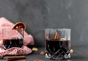 Auf dem Foto sieht man zwei Gläser mit Glühwein. Daneben sieht man Zimtstangen, Gewürznelken und Sternanis. | © SONNENTOR