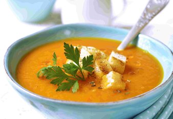 Auf dem Foto ist ein Teller mit Karotten-Orangen Suppe zu sehen. Darin sind Brotcroutons und Petersilie zu sehen. | © SONNENTOR