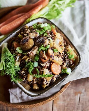 Auf dem Foto ist eine Schüssel mit Fenchel-Eintopf mit Quinoa zu sehen. Daneben liegen frische Kräuter und Karotten. | © SONNENTOR