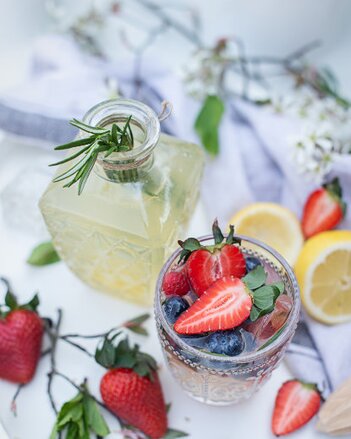 Auf dem Foto ist ein Glas Beeren "Gin" Fizz zu sehen. Darin sind Erdbeeren und Heidelbeeren zu sehen.  | © SONNENTOR