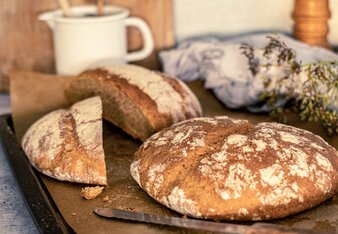 Auf dem Foto ist ein Laib Dinkelbrot zu sehen. Dahinter liegt noch ein Laib das in der Mitte durchgeschnitten ist. | © SONNENTOR