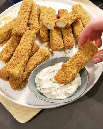 Auf dem Foto sind viele Tofu Sticks zu sehen. Man sieht wie jemand einen Tofu Stick in den Dip taucht. | © SONNENTOR