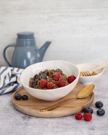 Auf dem Foto ist eine Schale mit Vanille-Beeren Porridge zu sehen. Das Porridge ist mit frischen Früchten garniert. | © SONNENTOR