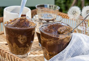 Auf dem Foto ist in eine Glas Löwenzahnwurzel-Stracciatella-Eis zu sehen. Darauf ist Schokoladensauce zu sehen. | © SONNENTOR