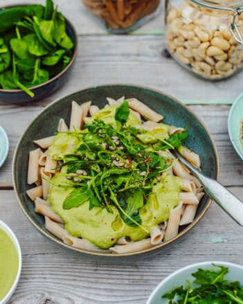 Auf dem Foto sieht man eine Schale mit Pasta. Darauf ist eine grüne Soße mit Rucola darauf zu sehen. | © SONNENTOR