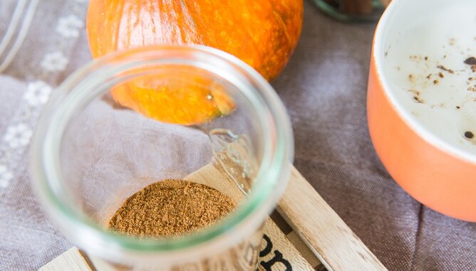 Auf dem Foto ist in einem Glas die Pumpkin Spice Gewürzmischung zu sehen. Im Hintergrund sieht man einen Kürbis. | © SONNENTOR