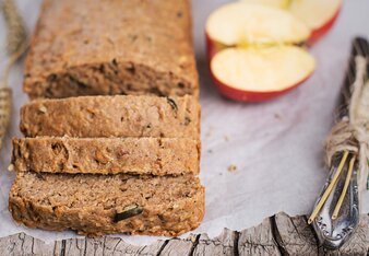 Auf dem Foto ist aufgeschnittenes Brot zu sehen. Daneben liegen Apfelhälften. | © SONNENTOR