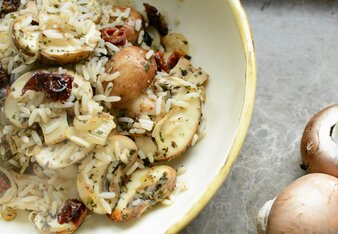 Auf dem Foto ist ein Teller mit Reispfanne zu sehen. Daneben liegen frische Champignons. | © SONNENTOR