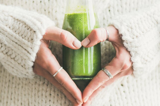 Auf dem Foto sieht man wie eine Frau eine Flasche mit grünem Smoothie in den Händen hält. | © SONNENTOR